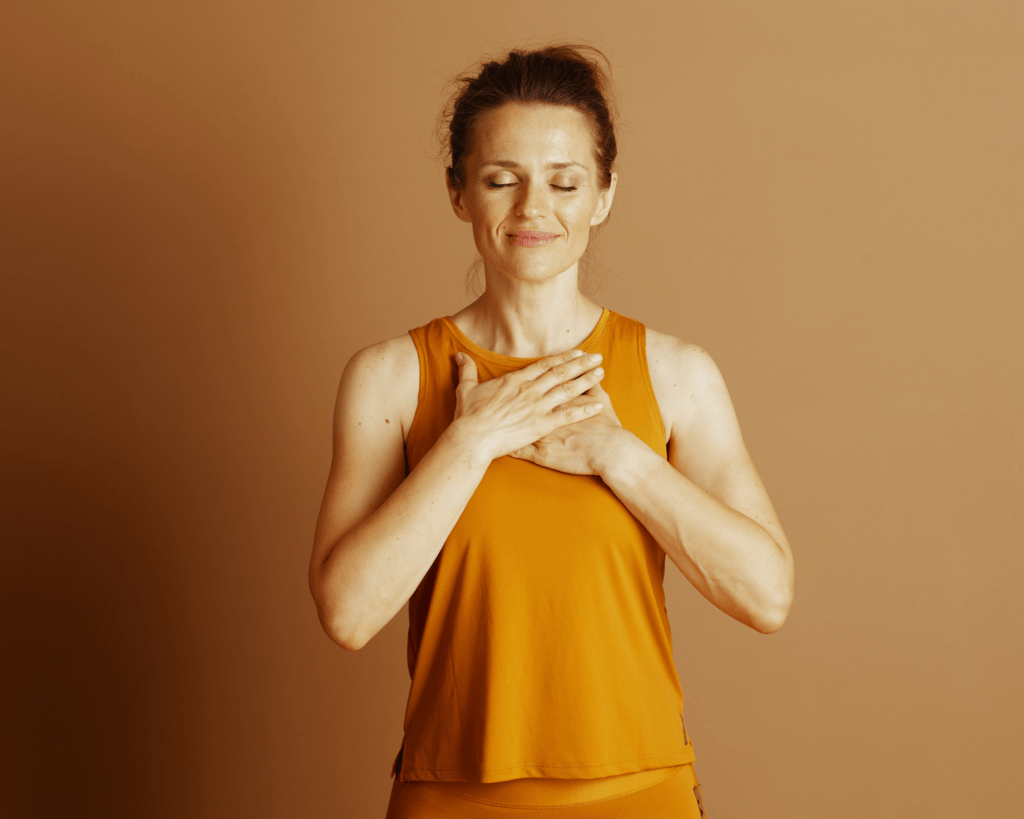Femme apaisée les mains sur le cœur, après avoir transformé sa colère