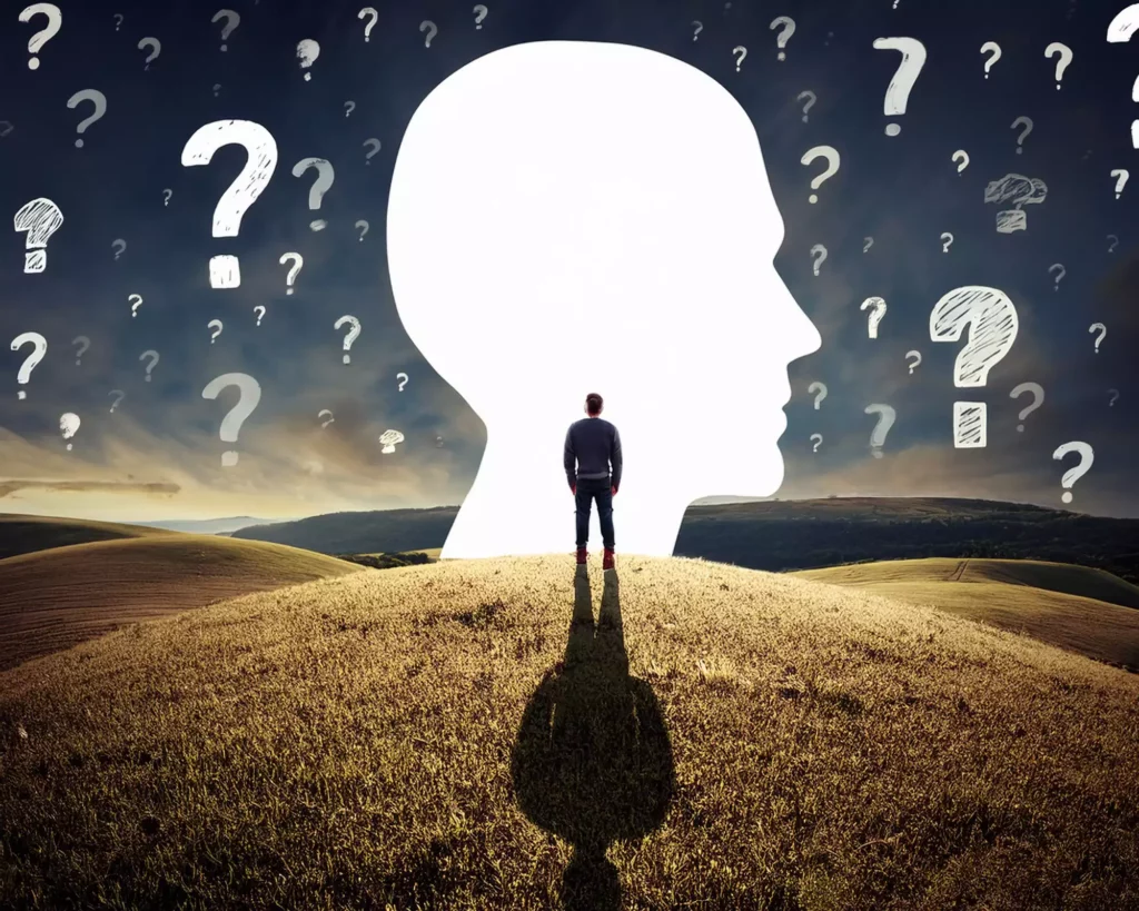  Homme face à une tête entourée de points d'interrogation, image des croyances limitantes et du questionnement intérieur